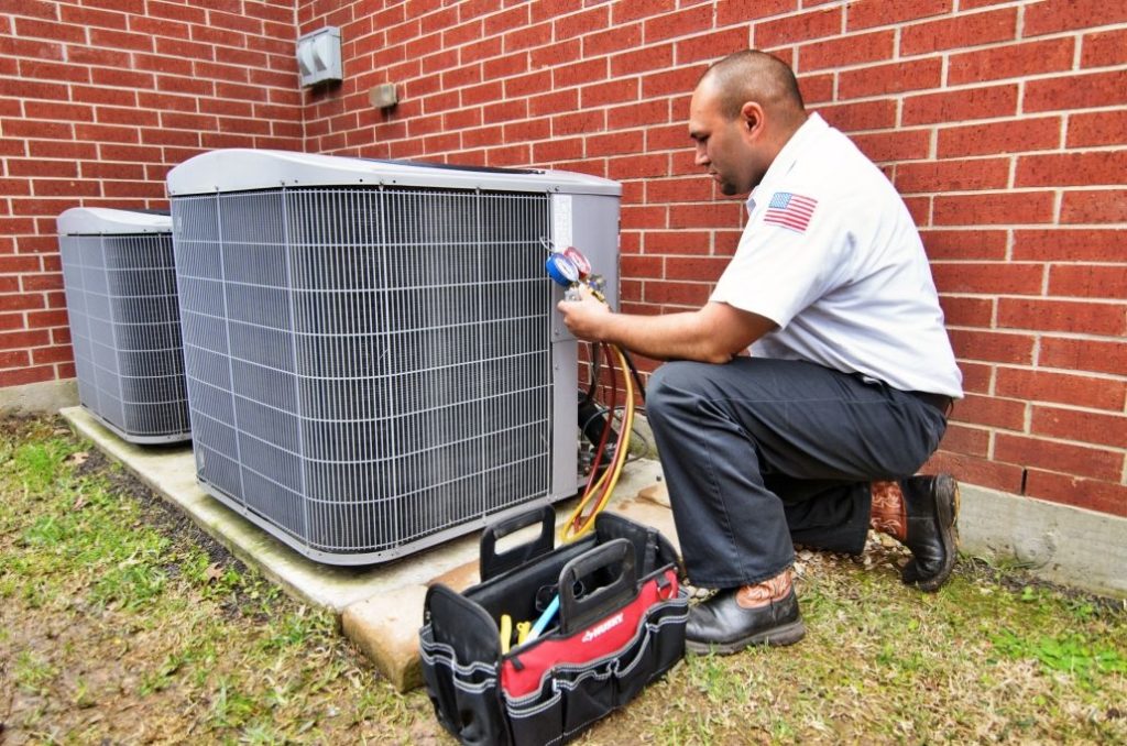 HVAC technician servicing outdoor AC unit.
