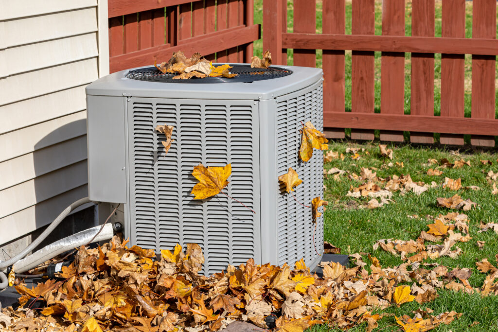 Air conditioner surrounded by fall leaves
