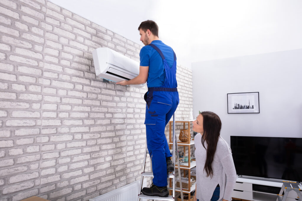 Male Technician Fixing Air Conditioner On Wall